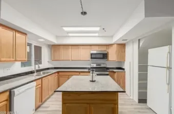 Shared community kitchen with a center island and full-size appliances