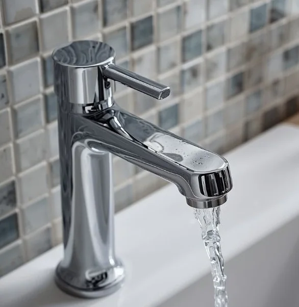 Running water from a modern chrome bathroom faucet